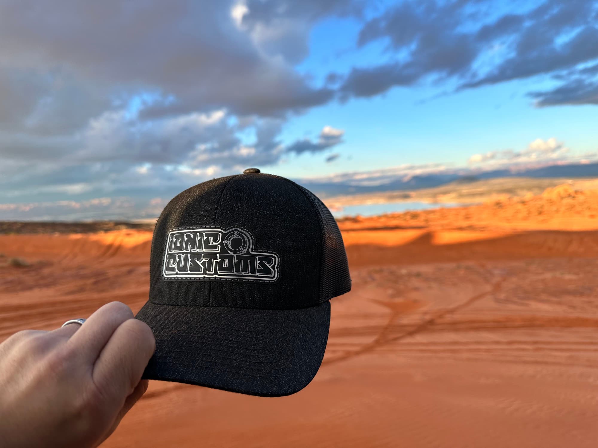 Blackout trucker hat with engraved leatherette patch in the desert