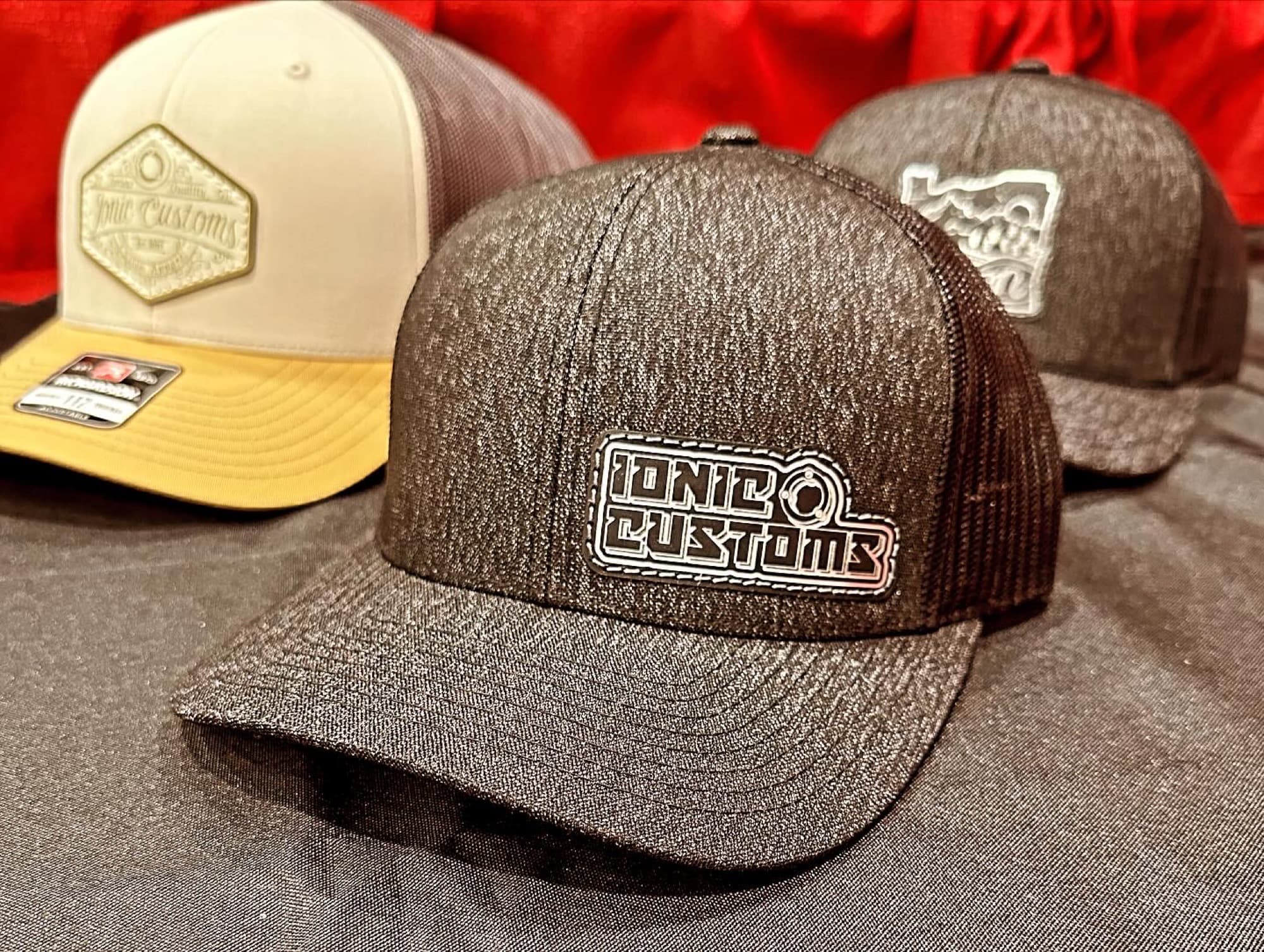 Three custom patch hats in bone, charcoal, and black colorways